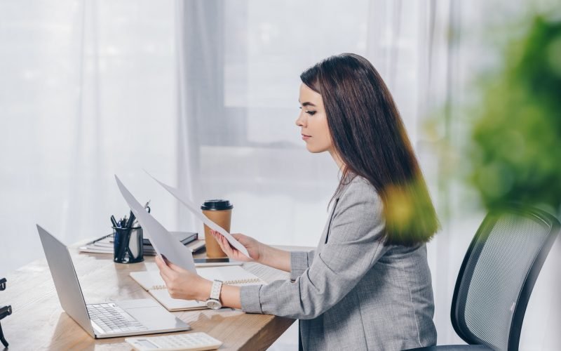 selective-focus-of-recruiter-holding-papers-at-table-in-office.jpg